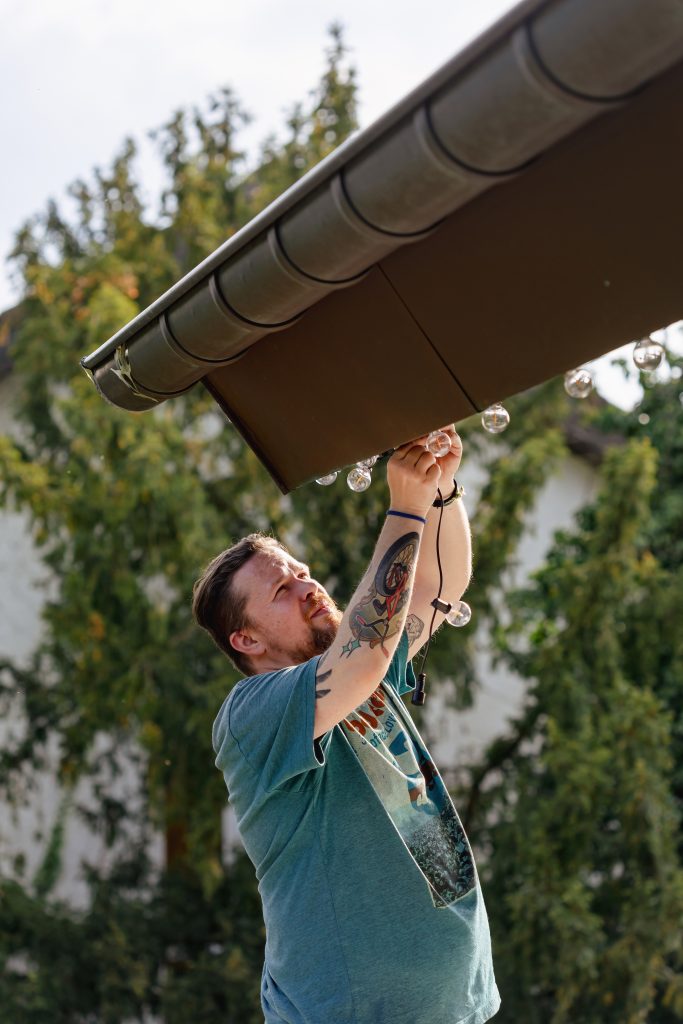 winter roof maintenance, roofing contractors Salem VA, homeowner clearing leaves from home gutter